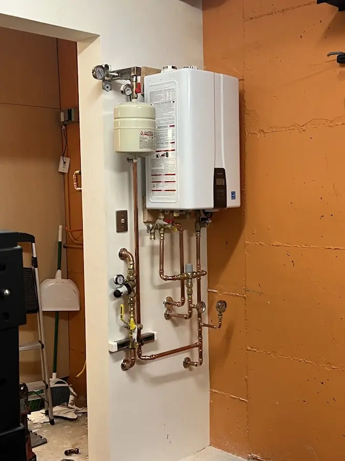Plumbing technician inspecting water heater connections in Deale
